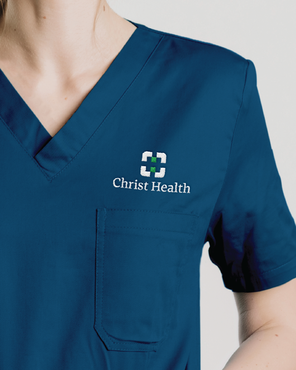 Christ Health doctor scrubs with logo.